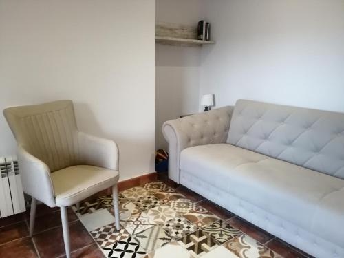 a living room with a couch and a chair at La Fragua del Canajal apartamentos in San Cosme