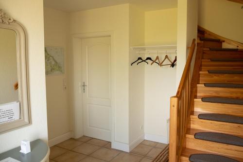 einen Flur mit einer Treppe und einer weißen Tür in der Unterkunft Familienidyll - Komfort, riesiger Garten & Badespaß in Rankwitz