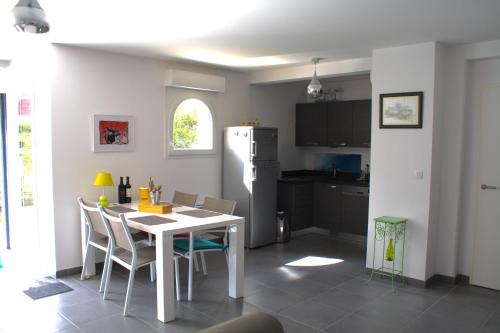 une cuisine avec une table, des chaises et un réfrigérateur dans l'établissement Capbreton - Plage - Port - Famille - Jardin, à Capbreton