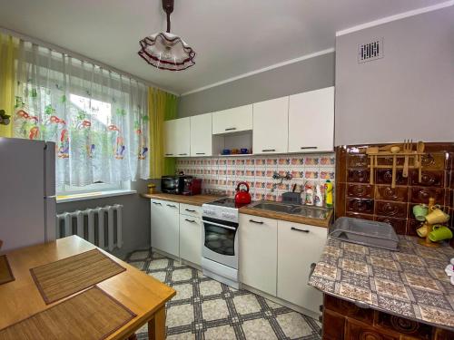 a kitchen with white cabinets and a counter top at Kwaterka Rosiczkowa in Augustów