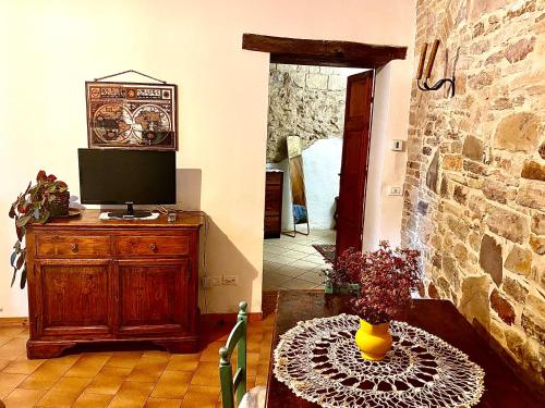 un salon avec une télévision et une table avec un vase dans l'établissement Assisi Anfiteatro Romano, à Assise