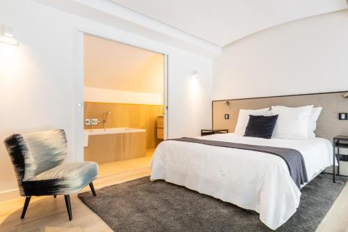 - une chambre avec un lit, une chaise et une baignoire dans l'établissement B2 Loft Duplex 175Blo-Paris Convention, à Paris