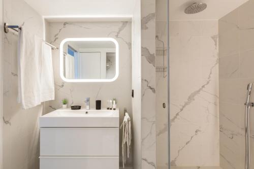 a white bathroom with a sink and a shower at B2 Loft Duplex 175Blo-Paris Convention in Paris
