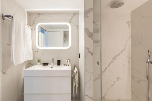 une salle de bain blanche avec un lavabo et une douche dans l'établissement B2 Loft Duplex 175Blo-Paris Convention, à Paris