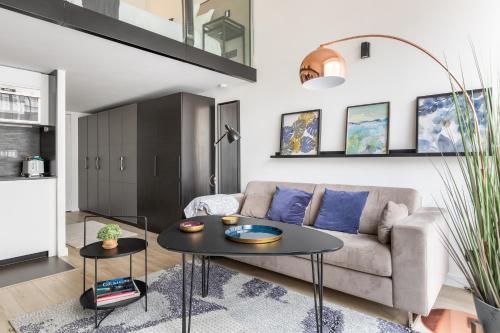 un salon avec un canapé et une table dans l'établissement B2 Loft Duplex 175Blo-Paris Convention, à Paris