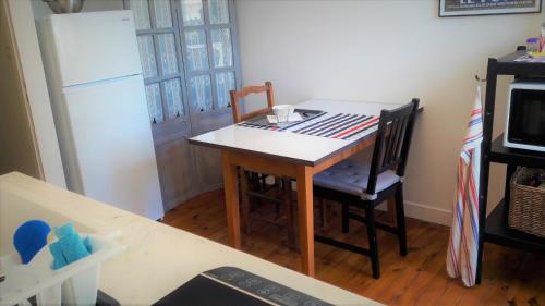 a kitchen with a table and two chairs and a refrigerator at Chez Martine et Philippe en Velay in Saint-Didier-en-Velay