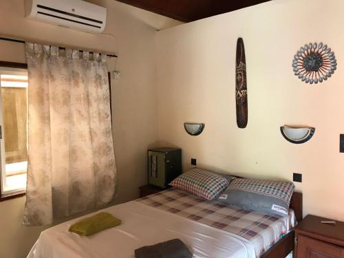 a bedroom with a bed and a baseball bat on the wall at Patta Patta Guest House in Serekunda