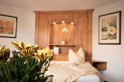 a bedroom with a bed and some plants at Hotel-Gasthof Der Wiesengrund in Bad Hindelang
