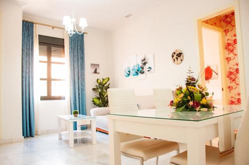ein Wohnzimmer mit einem Tisch und einem Sofa in der Unterkunft AlohaMundi Zaragoza III in Sevilla