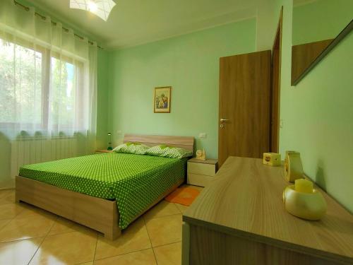 Dormitorio verde con cama y ventana en Bella Vista - Belvedere, en Montebuono