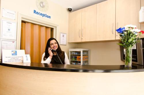 a woman sitting at a counter talking on a cell phone at Comfort Inn Edgware Road W2 in London