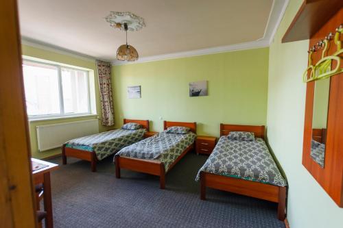 a hotel room with two beds and a window at Regina Guest House in Kaunas