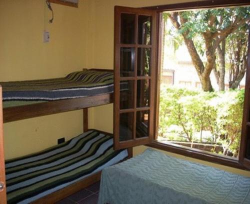 a room with two bunk beds and a window at El Guembe Hostel House in Puerto Iguazú