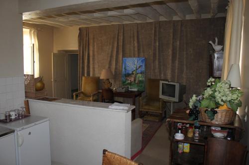 un salon avec une cuisine et un salon avec une télévision dans l'établissement A la Ferme de la Joie - Chambres d'Hôtes, à Chevannes