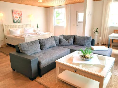ein Wohnzimmer mit einem Sofa und einem Bett in der Unterkunft Ferienbungalow Haus am Teich in Boltenhagen