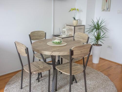 una mesa de madera y sillas en una habitación en Angellina Apartmani en Sremska Mitrovica
