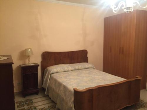 1 dormitorio con 1 cama con cabecero de madera y mesa en casa MARINO, en Caltabellotta