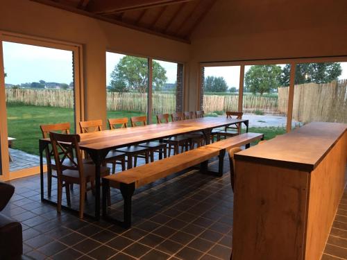 a large dining room with wooden tables and chairs at De Kasseihoeve in Kalken