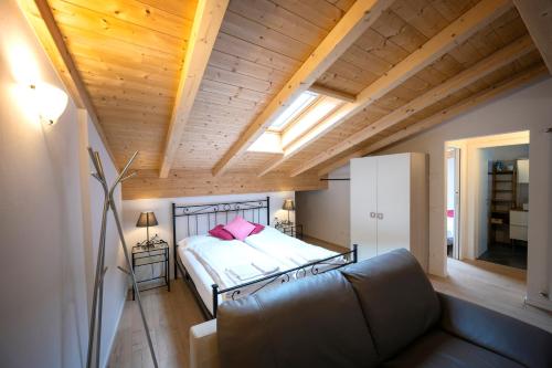 Un dormitorio con una cama y un sofá en una habitación. en Appartamenti Rivantica, en Riva del Garda