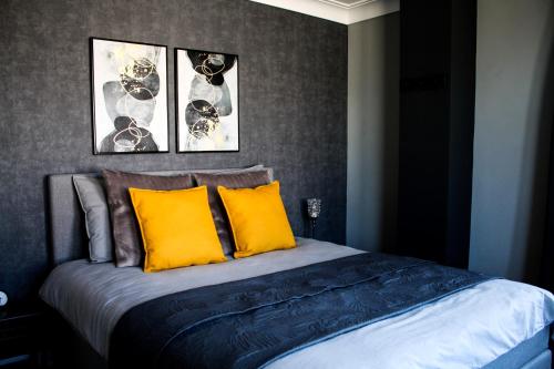 een slaapkamer met een bed met gele kussens bij A Bascule Bed and Breakfast Maastricht in Riemst
