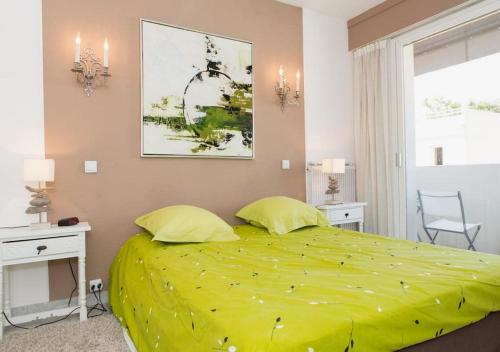 - une chambre avec un lit vert et 2 oreillers jaunes dans l'établissement Fettolina Palm Beach, Location Cannes front de mer et plage, à Cannes