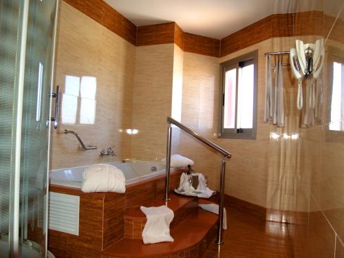 uma casa de banho com uma banheira e um chuveiro em vidro. em Hotel Montera Plaza em Los Barrios
