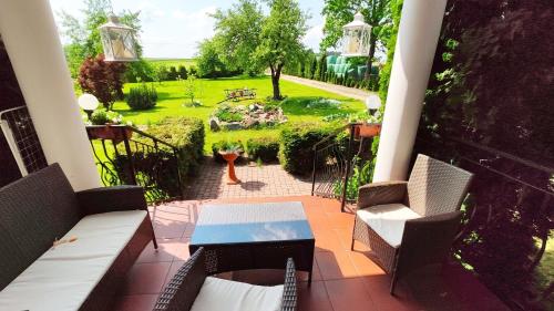 a balcony with a table and chairs and a garden at Agroturystyka u Pruszyńskich in Mońki