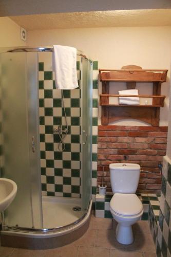 a bathroom with a toilet and a glass shower at Pensjonat Stary Spichlerz in Ełk