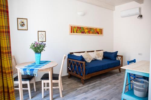 a living room with a blue couch and a table at B&B LE TRE CHIOCCIOLE in SantʼAntìoco