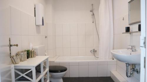a bathroom with a sink and a toilet and a bath tub at Kapitainskoje direkt am Hafen Flensburgs in Flensburg