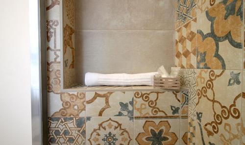 baño con espejo en la pared de azulejos en Cabanè Bed and Breakfast, en Garlenda