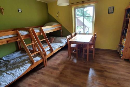 a room with two bunk beds and a table at Kaszubskie Siedlisko Szkodnikówka in Skwierawy