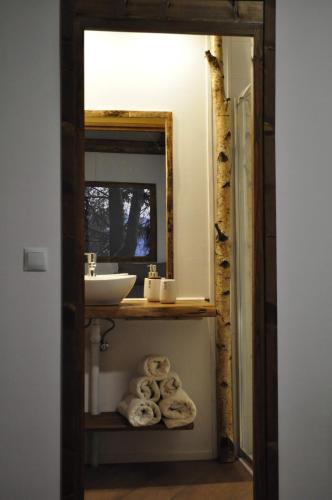 a bathroom with a sink and a mirror and towels at Secret do Gerês in Vieira do Minho