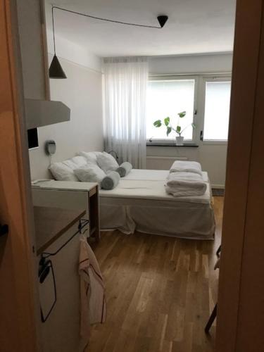 1 dormitorio con 1 cama y ventana con toallas en Lägenhet / studio i centrala Båstad, en Båstad