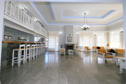 een grote woonkamer met witte meubels en een open haard bij Ifestos Hotel in Mirina