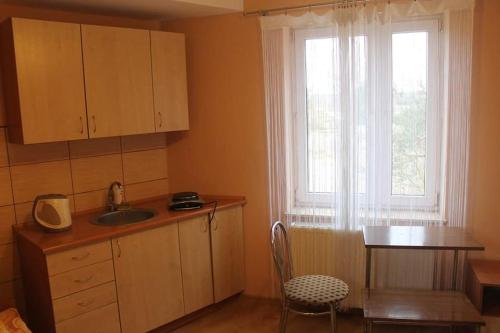 a kitchen with a sink and a table and a window at Bar Oaza in Szczerców