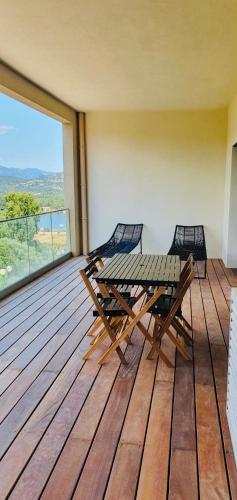 une terrasse en bois avec une table et des chaises dessus dans l'établissement Appartement 2 pièces dans le centre historique de Porto Vecchio, à Porto-Vecchio