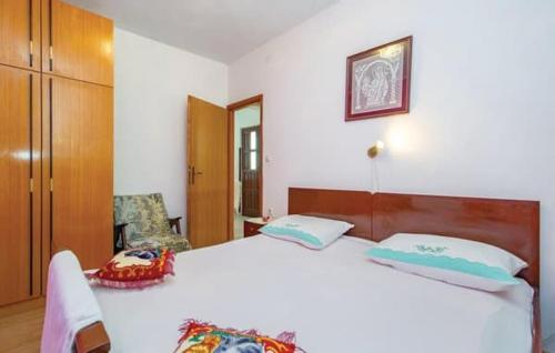 una camera con un grande letto bianco e una sedia di Apartments Luna a Zubovići