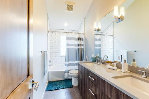 a bathroom with a sink and a toilet and a mirror at Woodhaven Hideaway in Frisco
