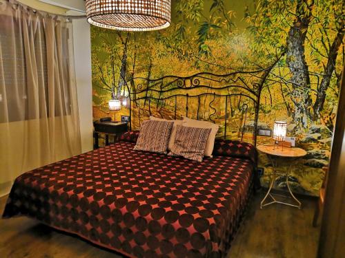 um quarto com uma cama grande e um mural de parede em La Posada del Casar em Casar de Palomero