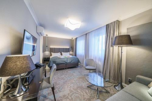 Habitación de hotel con cama y sofá en Strandhotel Duhnen en Cuxhaven
