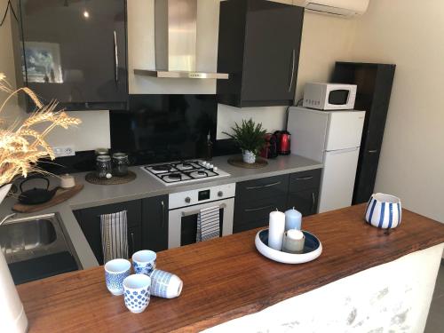 - une cuisine avec une table en bois et un comptoir dans l'établissement Mas provençal La Serallère au coeur des oliviers, à Venterol