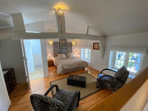 uma sala de estar com uma cama e duas cadeiras em Gite Les Buis de Saint Martin em Marssac-sur-Tarn