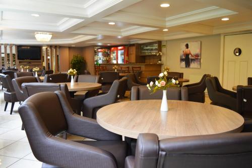 a dining room with tables and chairs with flowers on them at Sky Ville Hotel Canela in Canela