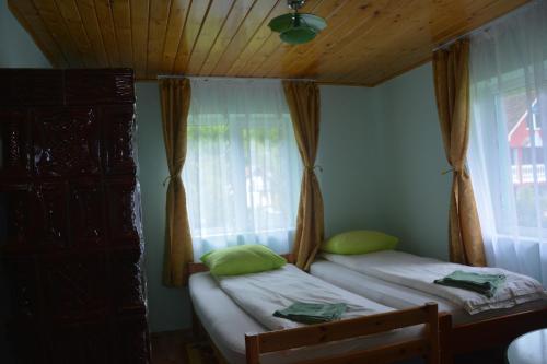 two twin beds in a room with a window at Casa Verde in Râu de Mori