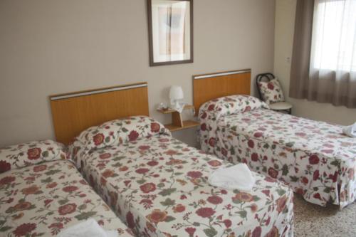 Кровать или кровати в номере Hostal Torre Mar