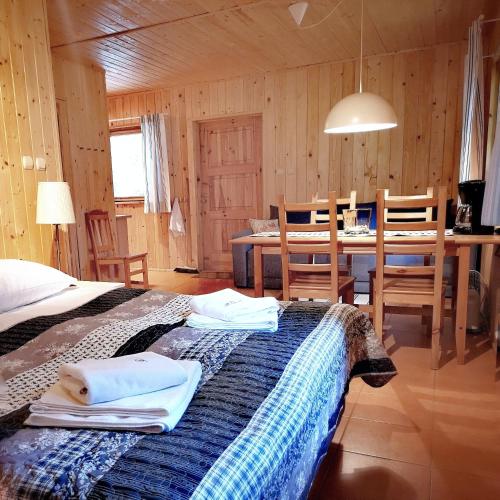 a room with a bed and a table and chairs at Mistral przy plaży Domki całoroczne in Ustka
