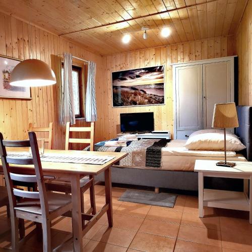 a bedroom with a bed and a table and chairs at Mistral przy plaży Domki całoroczne in Ustka