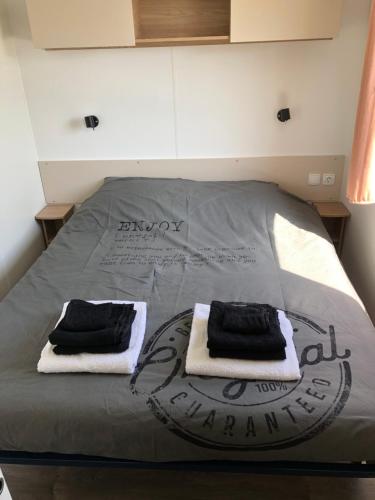 - un lit avec 2 serviettes dans l'établissement Chalet Enjoy, à Oostkapelle