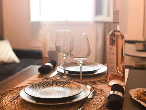 a table with two glasses and a bottle of wine at Studio Vieil Antibes - Saint Antoine in Antibes